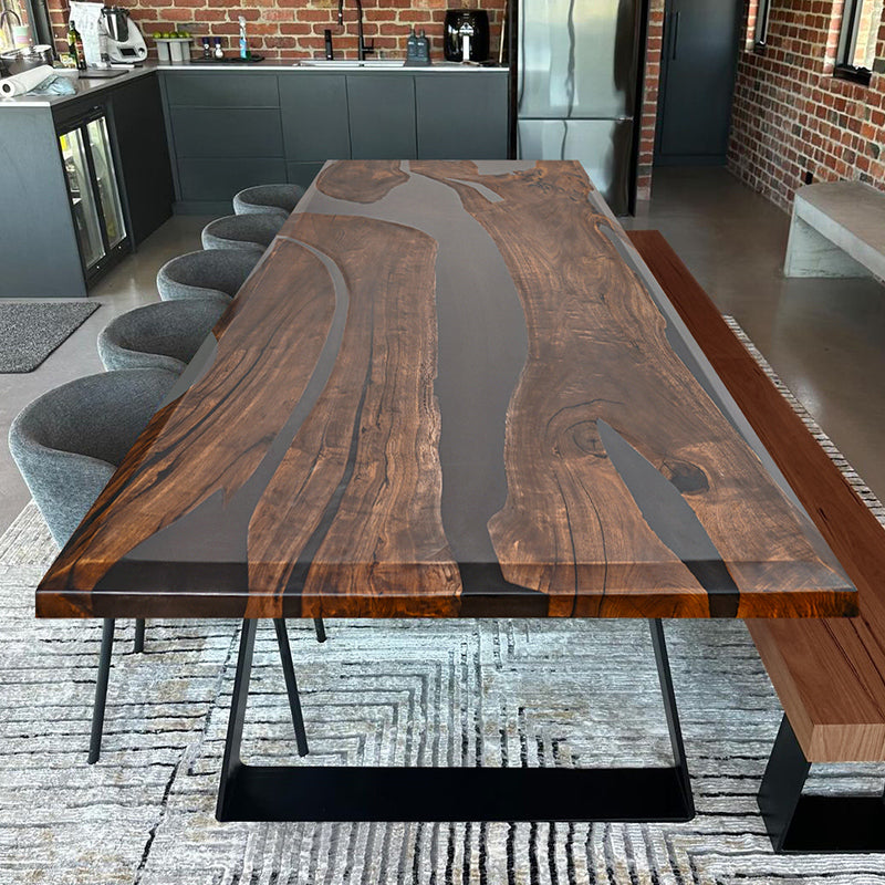 A luxury handcrafted epoxy river dining table made from solid wood and high-gloss resin, featuring a modern design with acrylic legs.