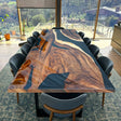 A handcrafted black epoxy resin river table with live edge wood, made from high-quality raw materials, perfect for dining or office use.