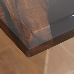 A luxury handcrafted epoxy river dining table made from solid wood and high-gloss resin, featuring a modern design with acrylic legs.