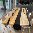 Handmade live edge epoxy resin dining table with natural wood slab and acrylic legs, perfect for modern interiors.