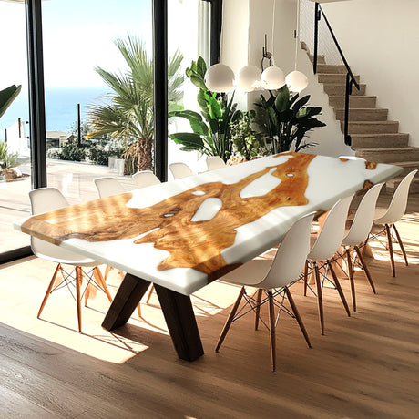 Rectangular epoxy - resin and wood dining table with a striking white resin and natural wood design, set in a bright room with large windows and white chairs.