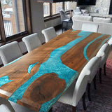 Rectangular dining table with a beautiful turquoise epoxy - resin inlay, surrounded by light - colored chairs.