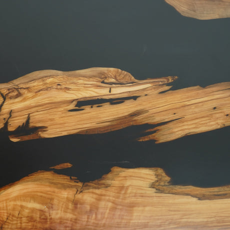 A live-edge dining table crafted from high-quality wood, featuring a sleek black epoxy - resin inlay