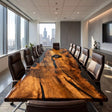 Handcrafted golden camphor wood conference table featuring glossy black epoxy resin, rich golden wood grain, and an elegant executive design