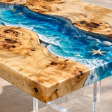 Luxury poolside patio featuring a poplar wood ocean wave epoxy coffee table with starfish accents, clear acrylic legs, and elegant outdoor lounge seating