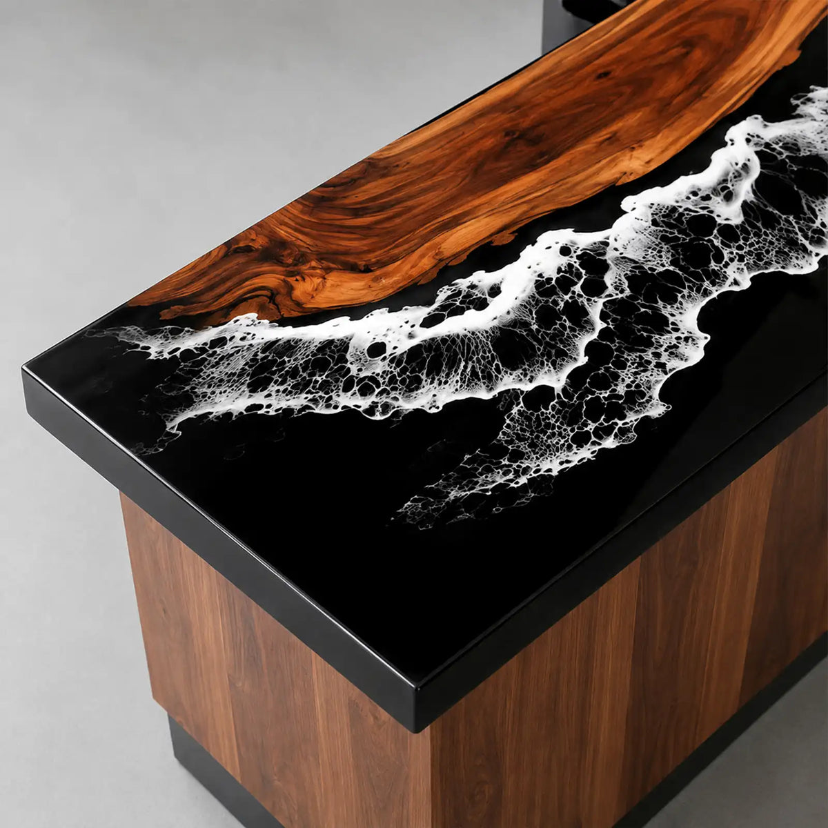 Modern L-shaped walnut reception counter featuring black ocean wave epoxy resin, warm wooden front panels, and a spacious wraparound work surface