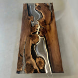 Modern organic dining table crafted from solid wood and glossy black resin