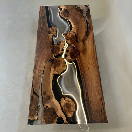Modern organic dining table crafted from solid wood and glossy black resin