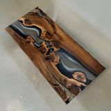 Natural edge solid wood dining table with dramatic black resin channels and wood grain