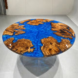 Round olive wood table with burlwood sections surrounding a glossy blue resin center