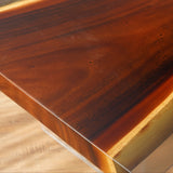 This rectangular dining table showcases a beautiful combination of rich, dark wood and a sleek, golden - toned epoxy - resin inlay that runs along its length. The natural wood grain is prominent, adding a rustic charm, while the glossy resin inlay provides a modern contrast, enhancing the table's visual appeal.